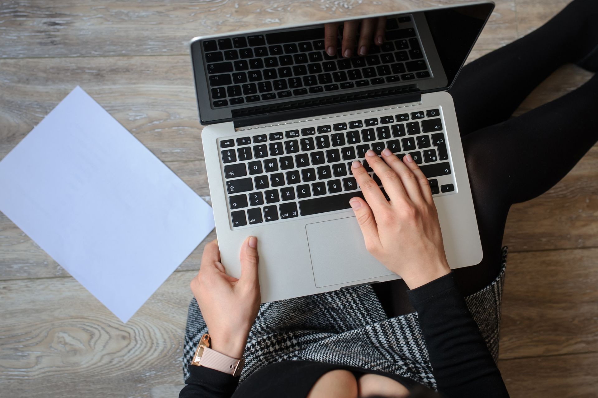 top view of a hot brunete in office outfit sitting on the floor and working on computer